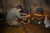Natasha Nomro, a Chukchi woman, trims the wick of an oil lamp inside the Polog (inner tent) of her Yaranga. Chuktskiy Peninsula, Chukotka, Siberia, Russia. 2010
