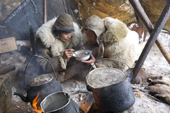 At mealtime in their Yaranga, Chukchi reindeer herders, Grisha Rahtyn & Natasha Nomro, share a bowl of hot reindeer stew. Chukotskiy Peninsula, Chukotka, Siberia, Russia. 2010