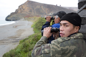 From the cliff top at Siriniki, Yupik hunter, Gennadiy Ankaughiy, keeps an eye out for Walrus in the sea below. Beringia National Park, Providensky Region, Chukotka, Russian Far East