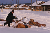 An Evenki man cutting firewood with a chainsaw in the village of Surinda. Evenkiya, Russia. 1997
