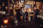 Two Sami reindeer herders relax in their hut after a days' work at their winter pastures. Lovozero, Murmansk, NW Russia. 2005