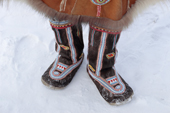 An Koryak woman wearing a pair of traditional reindeer skin boots decorated with bead work. Evensk, Magadan, E. Siberia. 2006