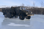 On a winter road, a truck travels through water on the surface of the frozen Garmanda River. Evensk, Magadan Region, E. Siberia, Russia. 2006