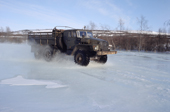 On a winter road, a truck travels through water on the surface of the frozen Garmanda River. Evensk, Magadan Region, E. Siberia, Russia. 2006