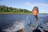 Sergei, a Nivkhi fisherman, drives his boat on the River Tym near Nogliki. Sakhalin Island, Russian Far East. 2006