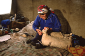 Janna, an Uilta (Orok) woman, repairs a traditional reindeer saddle at a herders' camp in Piltun Bay. Sakhalin Island, Russian Far East. 2006