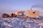 Smoke comes from the chimney of a Dolgan reindeer herder's balok (wooden hut built on sled runners)on the tundra. Taymyr, Northern Siberia, Russia. 2004