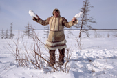 Saibore Momde, a Nganasan elder, displays two Ptarmigan he has caught with snares near a camp on the Kheta River. Taymyr, Northern Siberia, Russia. 2004