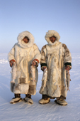 Nenets reindeer herders, Sasha Yeyvi (right) with Sertoharby, his grandfather, dressed in traditional reindeer skin winter clothes, holding Broad Whitefish they have just caught in a net under the ice. Gydan, W.Siberia, Russia. 2000