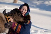 Sveta Pyak with Ava, her pet reindeer calf, at a Forest Nenets homestead in the forest near Numto. Khanty Mansiysk, Northwest Siberia, Russia