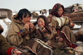 Sergey Seratetto, a Nenets man, eats with his daughter, Neseynya, sitting on knee during a meal break on the Spring migration. Yamal. Siberia. 1993