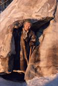 Granny 'Yaptik' an elderly Nenets woman emerges from her family's reindeer skin tent. Yamal, Siberia, Russia