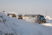 Trucks carrying large sections of gas pipe on a winter road near the Yurharovo gas field. Noviy Urengoi, Yamal, Western Siberia, Russia.