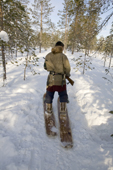 Alexei Piak, a Forest Nenets man, out hunting on skis in the forest during the winter. Purovsky region, Yamal, Western Siberia, Russia