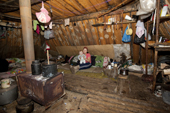 Lena Kuboleva, a young Selkup woman, with her daughter Violetta, inside a 'Poymot', (traditional Selkup turf winter hut), at a winter hunting camp in the forest near Ratta, Krasnoselkup, Yamal, Western Siberia, Russia. (2012)