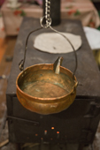 A Komi old copper bowl suspended by a stove and used to hold water for washing hands and face. Yamal, Western Siberia, Russia.