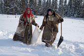 Two young Nenets women, Alina (left) and Sernya, dragging a bag of snow back to their camp to melt for water. Yamal, Northwest Siberia, Russa