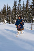 Eduard Khudi, a Nenets reindeer herder, carries an axe as he skiis into the forest to chop firewood near his winter camp. Yamal, Northwest Siberia, Russia