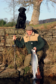 Michael Smith on Kinnaird with fish on the bank, and his labrador Tina. R. Tay Scotland