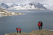 The guard with a rifle and some tourists visit the lateral moraine to a retreating Ankerbreen, St Jonsfjorden. Spitsbergen