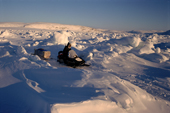 An Inuit hunter driving his snowmobile across tidal ice during a hunting trip.George River, N.Quebec, Nunavik, Canada.